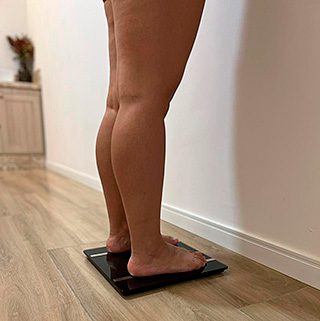 Pessoa realizando avaliação nutricional em balança, em atendimento da ECLINIC – Beleza e Bem-estar, em São José dos Campos.